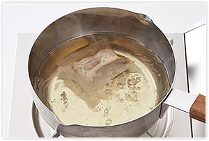「発酵うまみだし」でだしを取る。水500 ml と発酵うまみだしを鍋に入れて火にかけ、沸騰したら火を弱めて3分ほど煮出します。