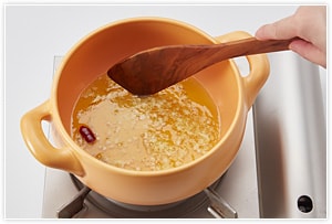 鍋にオリーブオイル、にんにくのみじん切りと鷹の爪を入れ、弱火で炒めます。　
