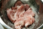 豚のかたまり肉は5㎜の厚さに切ってボールに入れ、軽く塩コショウしてから【調味料A】の酒を入れて混ぜて10分置き、残りのこめ油と片栗粉も入れ、手でもみ混ぜておきます。